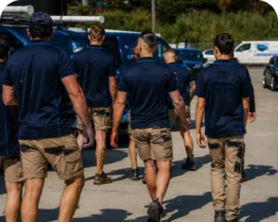 Plumbers walking to their service vans on a Queens Park job